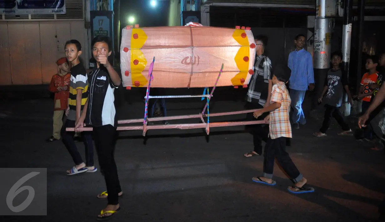Anak-anak membawa lampion berbentuk bedug saat pawai takbir lebaran di Jalan MT Haryono Semarang, Selasa, (5/7). Mereka membawa berbagai atribut mulai dari replika masjid , lampion hingga tokoh kartun. (Gholib)