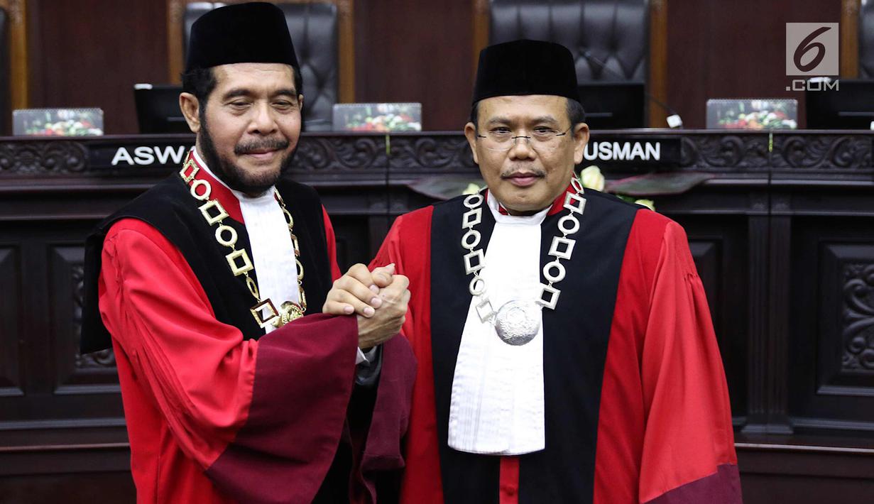 Ketua Mahkamah Konstitusi (MK) terpilih Anwar Usman (kiri) berjabat tangan dengan Wakil Ketua terpilih Aswanto usai acara pengucapan sumpah jabatan Ketua dan Wakil Ketua MK di gedung MK, Jakarta, Senin (2/4). (Liputan6.com/Immanuel Antonius)