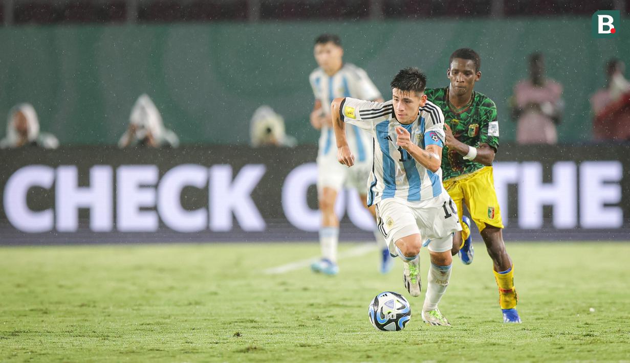 <p>Pemain Timnas Argentina U-17, Claudio Echeverri berhasil melewati seorang pemain Timnas Mali U-17 pada laga perebutan tempat ketiga Piala Dunia U-17 2023 di Stadion Manahan, Solo, Jumat (1/12/2023). (Bola.com/Bagaskara Lazuardi)</p>