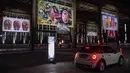 Orang-orang mengunjungi pameran seni dengan mengendarai mobil mereka melintasi gudang yang memajang lukisan dan foto di Sao Paulo pada 30 Juli 2020. Dengan galeri-galeri dan museum ditutup akibat pandemi virus corona, pemilik galeri seni Brasil meresmikan pameran drive-thru. (NELSON ALMEIDA/AFP)