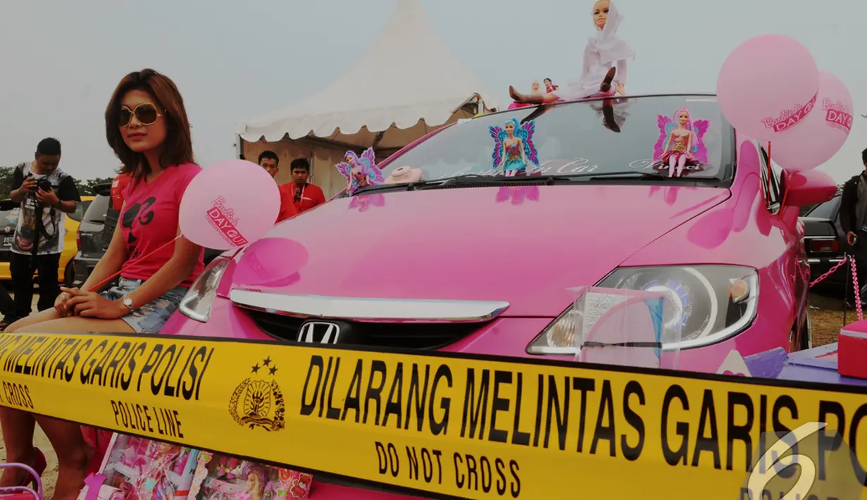Seorang wanita duduk disamping sebuah mobil dengan dominan warna pink pada kontest modifikasi mobil di Automodfest 2014, Jakarta, Minggu (9/11/2014) (Liputan6.com/Andrian M Tunay)