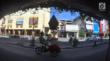 Pengendara becak motor melintas di kawasan wisata Malioboro, Yogyakarta, Selasa (31/10). Karena hari bebas pedagang kaki lima (PKL) trotoar dan jalur lambat di sepanjang jalan ini terlihat lapang dan bersih. (Liputan6.com/Gholib)