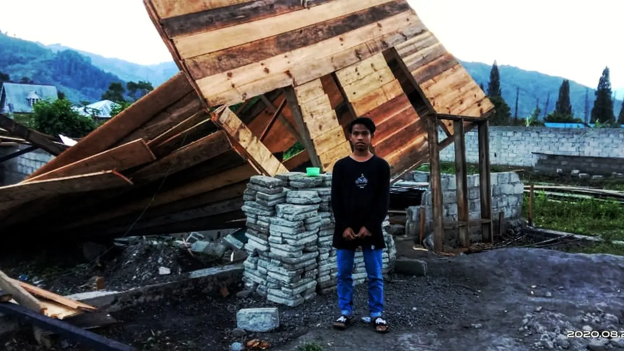 Seorang anak sedang berdiri di depan sebuah rumah yang roboh akibat terjangan angin puting beliung di Kecamatan Pegasing, Aceh Tengah (Liputan6.com/Ist)