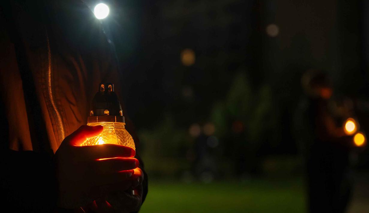 Orang-orang membawa lilin di tugu peringatan yang didedikasikan untuk petugas pemadam kebakaran dan pekerja yang meninggal setelah bencana nuklir Chernobyl, menjelang peringatan 40 tahunnya di Slavutych, Ukraina, Sabtu, 25 April 2026. (AP Photo/Dan Bashakov)