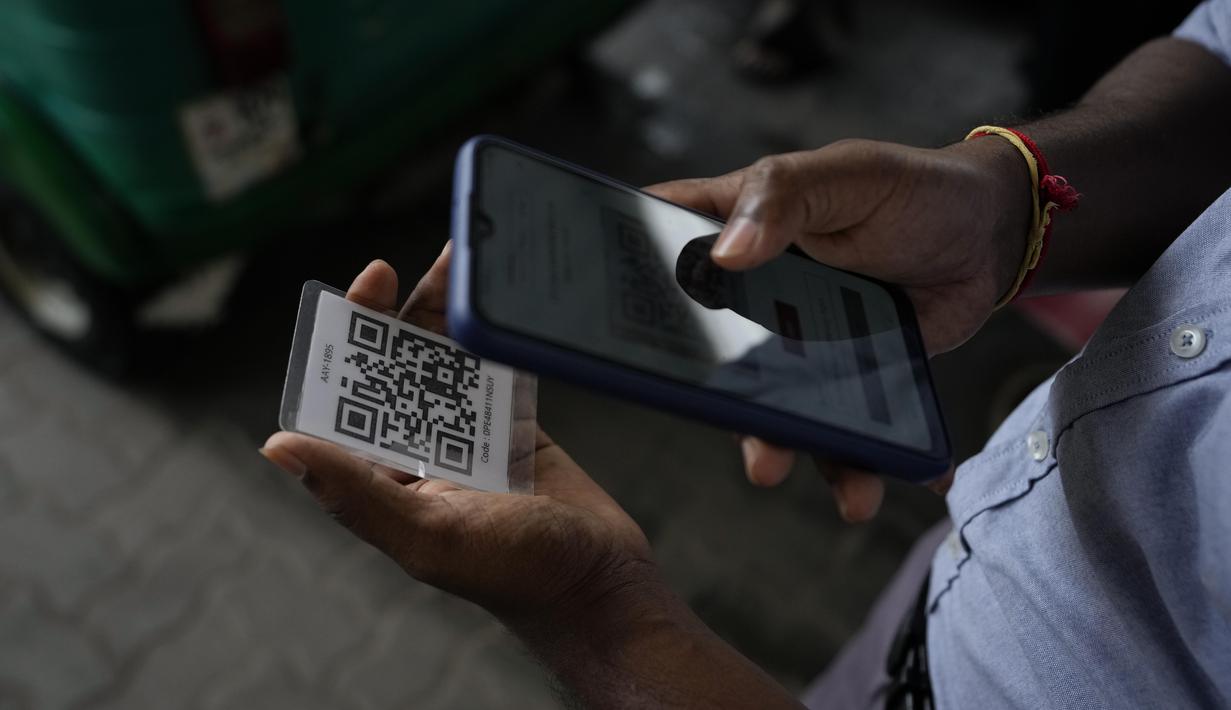 Seorang pekerja memindai kode QR sebelum mengisi bensin ke kendaraan di sebuah pompa bensin di Kolombo, Sri Lanka, Senin, 1 Agustus 2022. Sri Lanka memperkenalkan distribusi bahan bakar menggunakan kode QR pada hari Senin sebagai bagian dari penerapan kuota mingguan untuk pengendara. (AP Photo/Eranga Jayawardena)