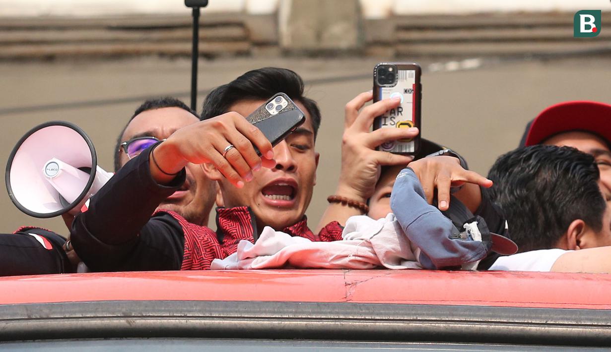 Reaksi pemain Timnas Indonesia U-22, Pratama Arhan saat tertimpuk seragam dari salah satu pelajar SMA Negeri 7 Jakarta Pusat saat pawai pawai bertajuk Kira87uara Kontingen SEA Games 2023 yang berlangsung dari Kemenpora hingga Stadion Utama Gelora Bung Karno (SUGBK), Senayan, Jakarta, Jumat (19/5/2023). Acara tersebut merupakan bentuk perayaan keberhasil kontingen Indonesia yang telah melampaui target medali emas di SEA Games 2023 dan kesuksesan Timnas Indonesia U-22 yang telah mengakhiri puasa gelar 32 tahun di SEA Games 2023. (Bola.com/Bagaskara Lazuardi)