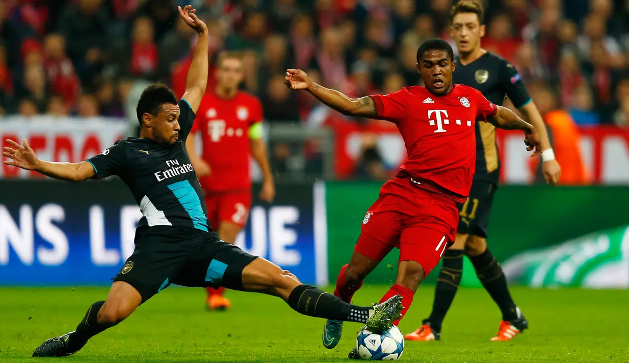 Gelandang Muenchen, Douglas Costa (kanan) berusaha melewati gelandang Arsenal, Francis Coquelin pada lanjutan Grup F liga champions di stadion Allianz Arena, Munich, Jerman (4/11). Muenchen menang atas Arsenal dengan skor 5-1. (Reuters/Michael Dalder) 