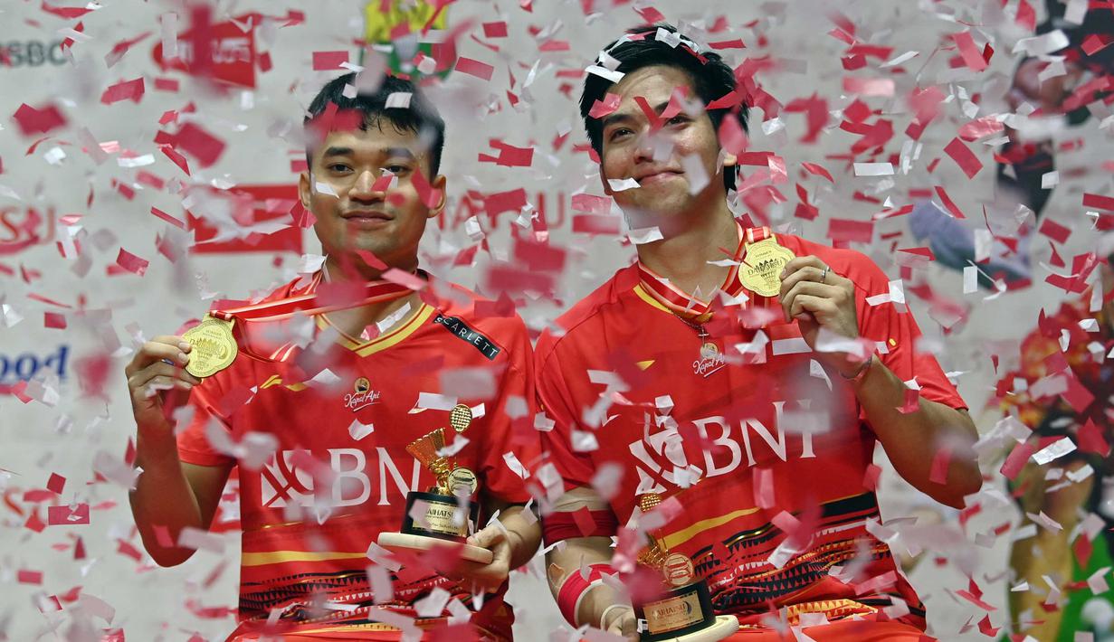Ganda putra Indonesia, Leo Rolly Carnando (kiri) dan Daniel Marthin berpose di podium kemenangan setelah mengalahkan Kim Astrup dan Anders Skaarup Rasmussen dari Denmark pada final turnamen bulu tangkis Indonesia Masters di Jakarta, 28 Januari 2024. (ADEK BERRY/AFP)