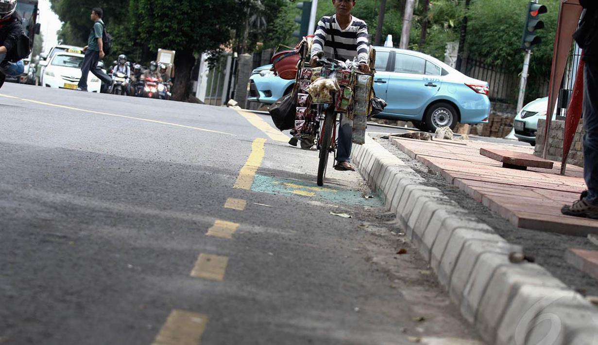 Pedagang menggunakan sepeda melewati jalur khusus sepeda yang disediakan di Jalan Imam Bonjol, Jakarta. Foto diambil pada Kamis (4/12/2014). (Liputan6.com/Faizal Fanani)
