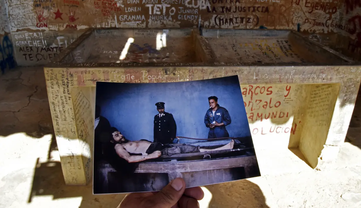 Seorang wartawan menunjukkan salinan foto dari gambar Che Guevara yang diambil oleh wartawan AFP, Marc Hutten pada tanggal 10 Oktober 1967 di Bolivia (30/9). Che Guevara tewas pada 9 Oktober 1967. (AFP Photo/Aizar Raldes)