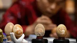 Zhang Xiaohe membuat kerajinan ukiran telur di sebuah lokakarya warisan budaya takbenda di Shijiangzhuang, China pada 17 April 2020. Ukiran telur sering disebut "seni yang paling rapuh", karena membutuhkan ketelitian dan perhatian tinggi sebelum, selama dan setelah pembuatannya. (Xinhua/Chen Qibao)