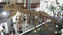 Anak-anak berjalan melewati replika fosil kerangka dinosaurus selama Pameran Paleontologi di Museum Nasional Taiwan di Taipei pada 11 Juli 2023. (AFP/Sam Yeh)