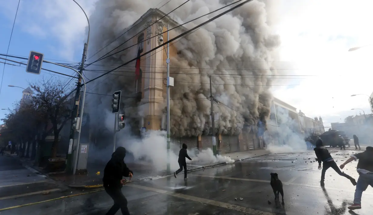 Kericuhan terjadi saat unjuk rasa di gedung Kongres di Valparaiso, Chili, Sabtu (21/5). Seorang petugas keamanan tewas saat bentrok pendemo dengan polisi. (AFP Photo/Claudio Reyes)