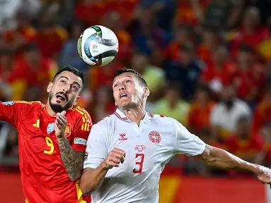 Penyerang Spanyol, Joselu (kiri) dan bek Denmark, Jannik Vestergaard berebut bola sundulan saat pertandingan ketiga Grup 4 UEFA Nations League 2024/2025 di Stadion Enrique Roca de Murcia, pada Sabtu 12 Oktober 2024 atau Minggu (13/20/2024) dini hari WIB. (JOSE JORDAN/AFP)