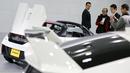 Pengunjung terpesona melihat mobil Honda S660 di markas besar Honda Motor Co di Tokyo, Jepang, (24/2). Mobil Honda S660 adalah mobil sport yang memiliki dua tempat duduk berkatagori mobil yang sangat kecil. (REUTERS/Thomas Peter)