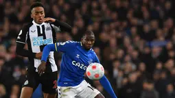 Gelandang Newcastle United Joe Willock (kiri) berebut bola dengan gelandang Everton Abdoulaye Doucoure pada lanjutan Liga Inggris di Stadion Goodison Park, Liverpool, Jumat (18/3/2022) dini hari WIB. Bertindak sebagai tuan rumah, Everton menang tipis 1-0.  (Anthony Devlin / AFP)