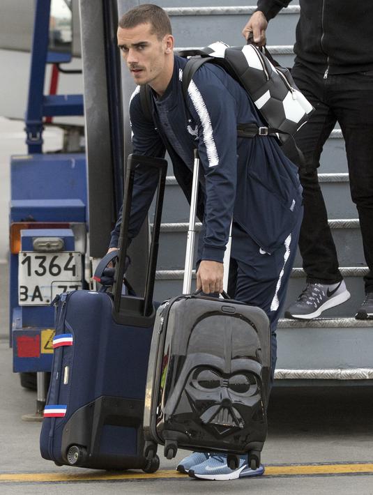 Antoine Griezmann mengangkat dua koper saat tiba di Sheremetyevo international airport, Moskow, Rusia, (10/6/2018). Pada laga perdana Prancis akan melawan Australia. (AP/Pavel Golovkin)