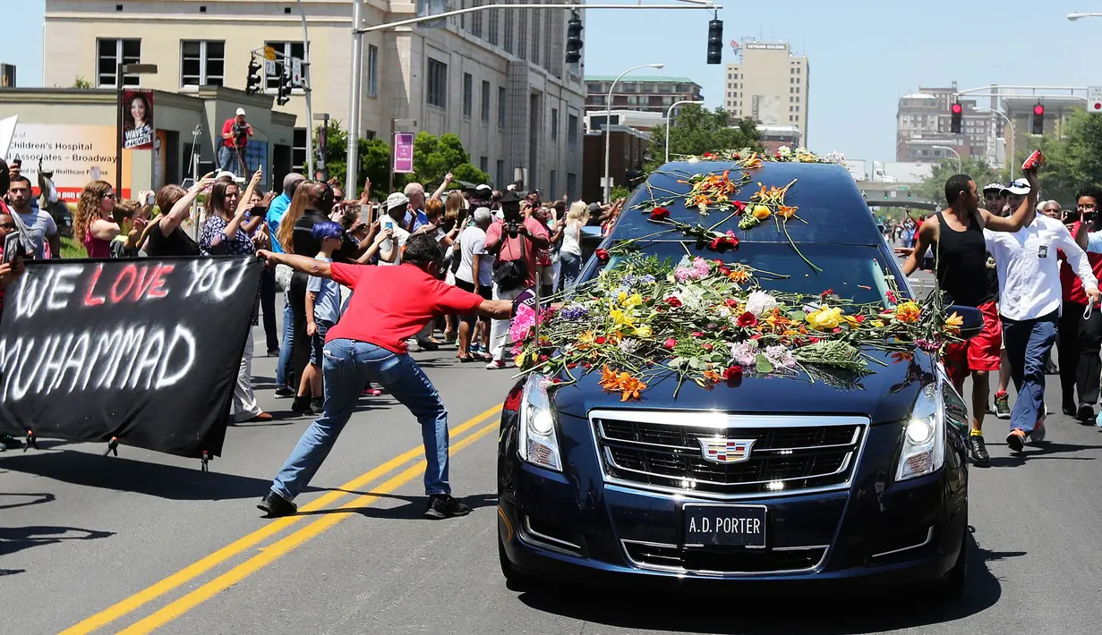 Seorang pria mengulurkan tangan untuk menyentuh mobil jenazah yang membawa jasad mantan petinju dunia, Muhammad Ali saat akan dimakamkan di Louisville, Kentucky, AS, 10 Juni 2016. (REUTERS / Adrees Latif)