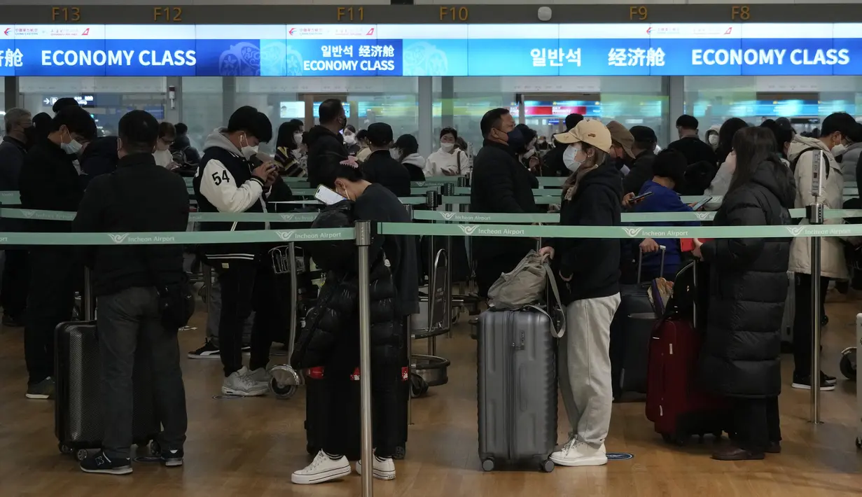 Penumpang antre menaiki pesawat menuju China di Bandara Internasional Incheon di Incheon, Selasa (10/1/2023). China menangguhkan visa pada Selasa bagi warga Korea Selatan yang datang ke negara itu untuk pariwisata atau bisnis sebagai pembalasan yang nyata untuk persyaratan pengujian COVID-19 pada pelancong China. (AP Photo/Ahn Young-joon)