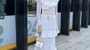 Laura Basuki tampil memesona dengan dress putih layering lengan panjang dari Chanel, ia juga membawa mini bag dari brand yang serupa. [@laurabas]