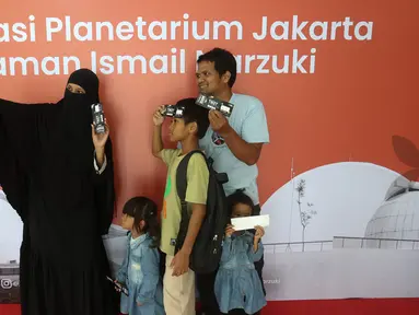 Pengunjung berswafoto sebelum memasuki area Planetarium di Taman Ismail Marzuki, Jakarta, Kamis (25/12/2025). Planetarium Taman Ismail Marzuki (TIM) akhirnya dibuka kembali. Planetarium Taman Ismail Marzuki (TIM) akhirnya dibuka kembali. (Kapanlagi.com/Budy Santoso)