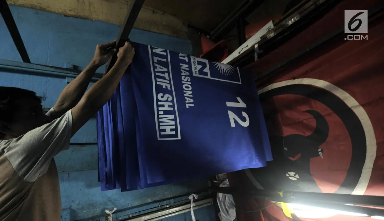 Pekerja merapikan bendera salah satu partai politik yang telah selesai dibuat di Percetakan Andalas Jaya, Jakarta, Rabu (2/1). Tahun politik membawa berkah bagi pengusaha sablon bendera dan spanduk partai. (Merdeka.com/Iqbal Nugroho)