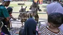 Pengunjung memberi makan jerapah di Kebun Binatang Surabaya, Jawa Timur, selama libur sekolah sekaligus jelang Natal dan Tahun Baru pada Minggu 21 Desember 2025. Memasuki libur sekolah dan jelang perayaan Natal 2025 serta Tahun Baru 2026, Kebun Binatang Surabaya (KBS) kembali menjadi destinasi favorit keluarga. (JUNI KRISWANTO/AFP)