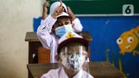 Siswa mengikuti uji coba pembelajaran tatap muka (PTM) perdana di SD Negeri 14 Pondok Labu, Jakarta, Senin (30/8/2021). Pembelajaran tatap muka (PTM) terbatas Tahap 1 di Provinsi DKI Jakarta digelar dengan kapasitas 50 persen pada setiap satuan pendidikan. (Liputan6.com/Faizal Fanani)