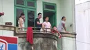 Warga berada di atas teras rumah jelang kirab atau arak-arakan acara resepsi Kahiyang Ayu Siregar-Bobby Nasution di Kota Medan, Sumatera Utara Minggu (26/11). (Liputan6.com/Johan Tallo)