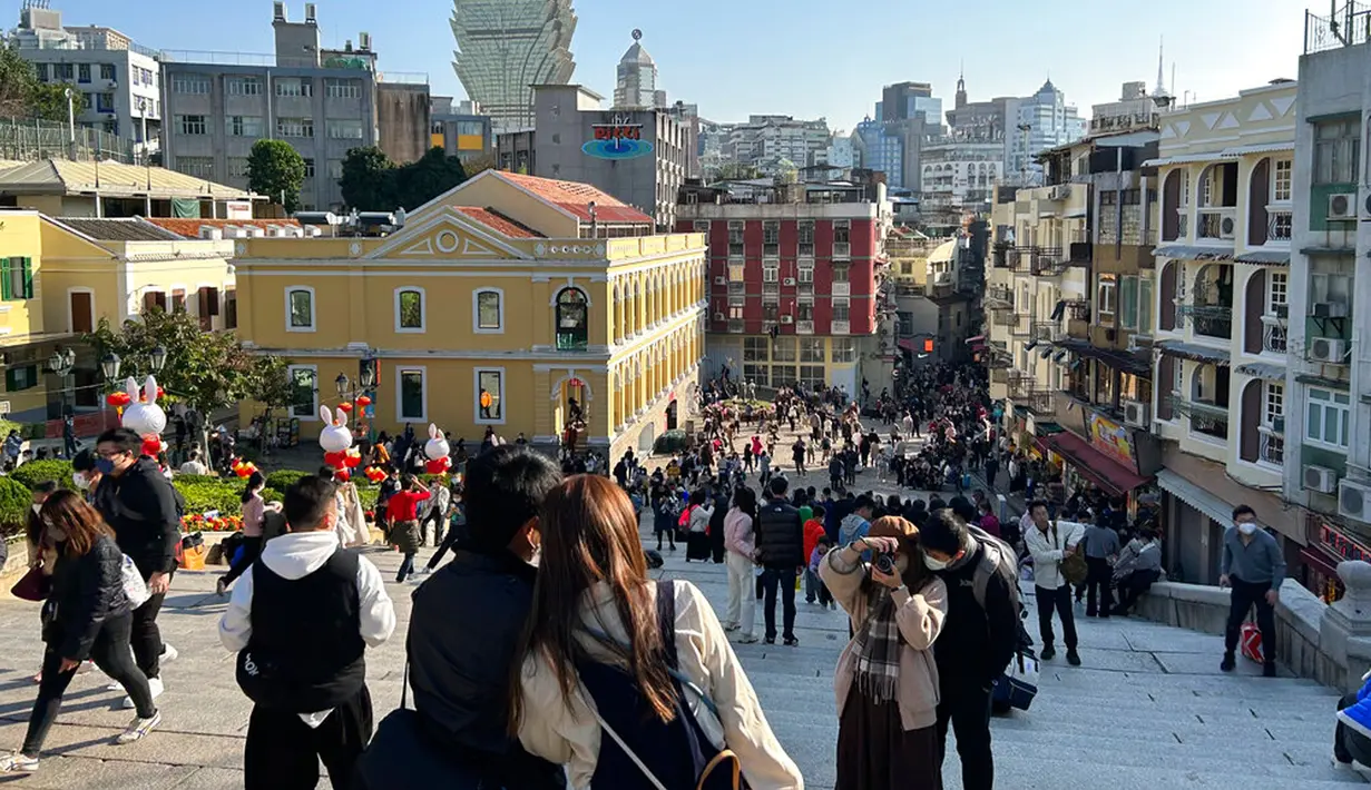Pelancong dari China daratan berkumpul dekat Reruntuhan St. Paul's, tujuan wisata di Makau, 18 Januari 2022. Ledakan pariwisata China yang diharapkan selama liburan Tahun Baru Imlek minggu depan tampaknya akan lebih cepat terjadi. (AP Photo/Kanis Leung)