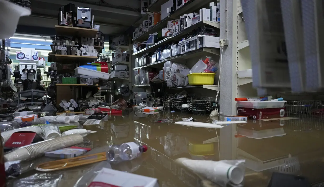 Barang-barang mengapung di atas air di dalam sebuah toko yang dilanda banjir saat hujan deras semalaman di Alges, tepat di luar Lisbon, Selasa (13/12/2022). Badai Atlantik menghantam semenanjung Iberia, meninggalkan jejak kehancuran pada Selasa, terutama di Ibu kota Portugal,  Lisbon, sebelum pindah ke timur ke Spanyol.  (AP Photo/Armando Franca)