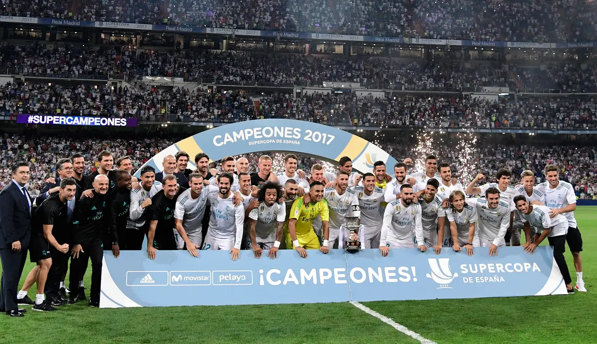 Para pemain Real Madrid berpose dengan trofi merayakan kemenangan atas Barcelona pada Piala Super Spanyol 2017 di stadion Santiago Bernabeu, Spanyol (16/8). Real Madrid menang 2-0 atas Barcelona dengan skor agregat 5-1. (AFP Photo/Javier Soriano)