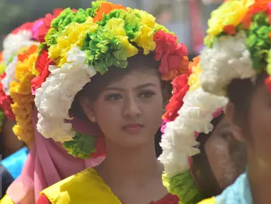 Peserta wanita mengenakan mahkota dari bunga saat pawai Tradisi Ngarot di Indramayu, Minggu, (9/10). Mahkota bunga dalam Tradisi Ngarot diartikan sebagai lambang kesucian. (Liputan6.com/Gholib)