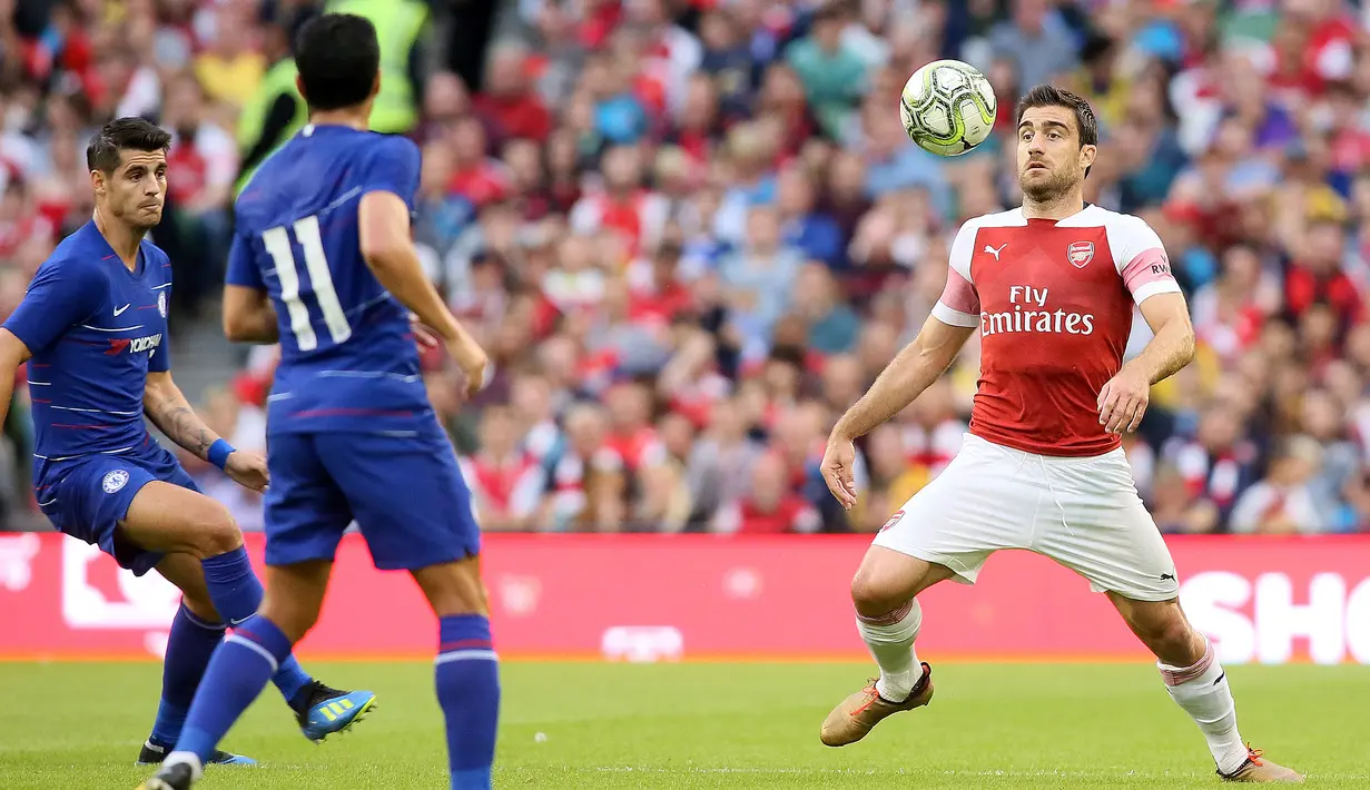 Bek Arsenal Sokratis Papastathopoulos berusaha mengontrol bola dari kawalan pemain Chelsea selama pertandingan International Champions Cup (ICC) di Stadion Aviva di Dublin (1/8). Arsenal menang atas Chelsea lewat adu penalti 6-5. (AFP Photo/Paul Faith)