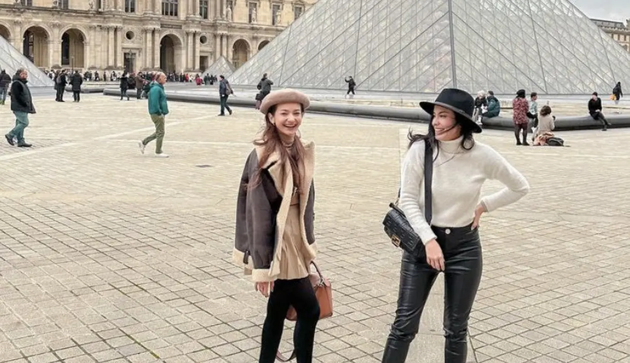 Medina mengenakan turtleneck putih dipadukan celana latex hitamnya, saat berada di Paris bersama Enzy yang mengenakan pakaian earth tone. Credit: (@medinadinaaa)