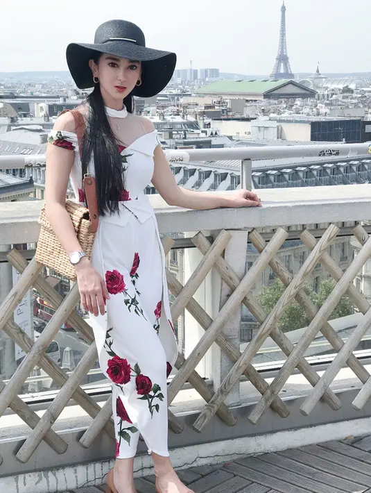 Gayanya selalu cantik dengan menggunakan busana apapun. Seperti ketika ia memakai gaun panjang bermotif bunga serta topi hitam besar. Berlatar belakang Menara Eiffel, Natasha sukses bikin terpesona. (Liputan6.com/IG/@natasharatulangi)