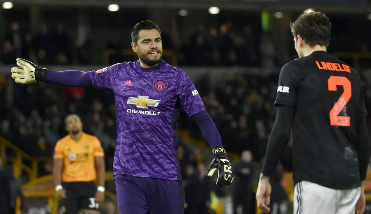 Kiper Manchester United, Sergio Romero, berbincang dengan Victor Lindelof saat melawan Wolverhampton Wanderers, Romain Saiss, pada laga Piala FA di Stadion Molineux, Sabtu (4/1/2020). Kedua tim bermain imbang 0-0. (AP/Rui Vieira)