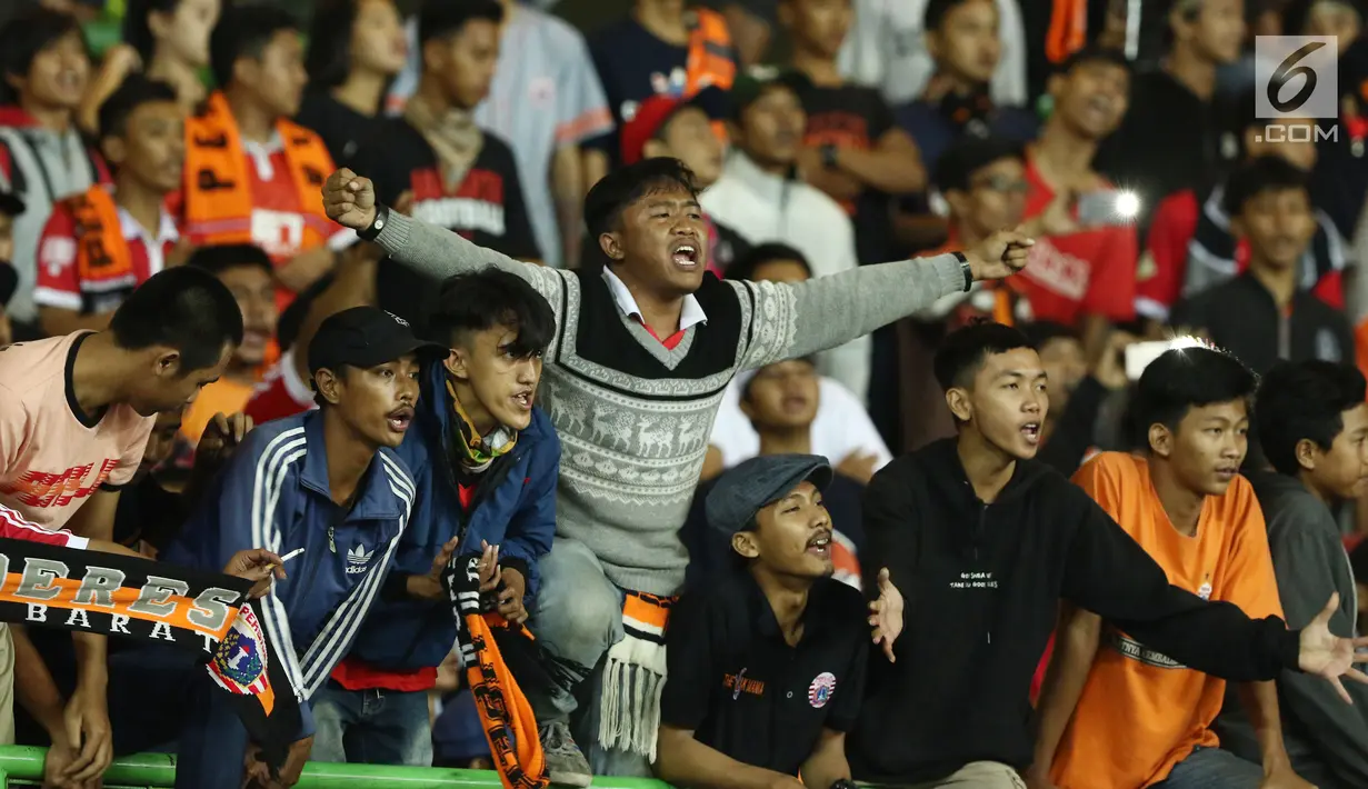 Suporter Persija membentangkan tangan merayakan kemenangan tim Macan Kemayoran atas Perserui pada lanjutan Liga 1 Indonesia di Stadion Patriot Candrabhaga, Bekasi, Selasa (13/6). Persija menang telak 3-0 atas perserui. (Liputan6.com/Helmi Fithriansyah)