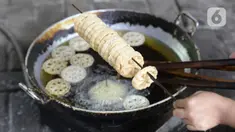 Pekerja menggoreng jajanan tradisional kembang goyang di Kelurahan Karangan, Setu, Tangerang Selatan, Banten, Kamis (6/8/2020). Jajanan kue kering berbentuk bunga tersebut dijual dengan harga Rp 5 ribu per bungkus. (merdeka.com/Dwi Narwoko)