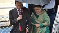 Presiden Joko Widodo atau Jokowi didampingi Ibu Iriana saat turun dari Pesawat Kepresidenan yang mendarat di Bandara Sydney, Australia, Sabtu (25/2). (AFP/Saeed Khan)