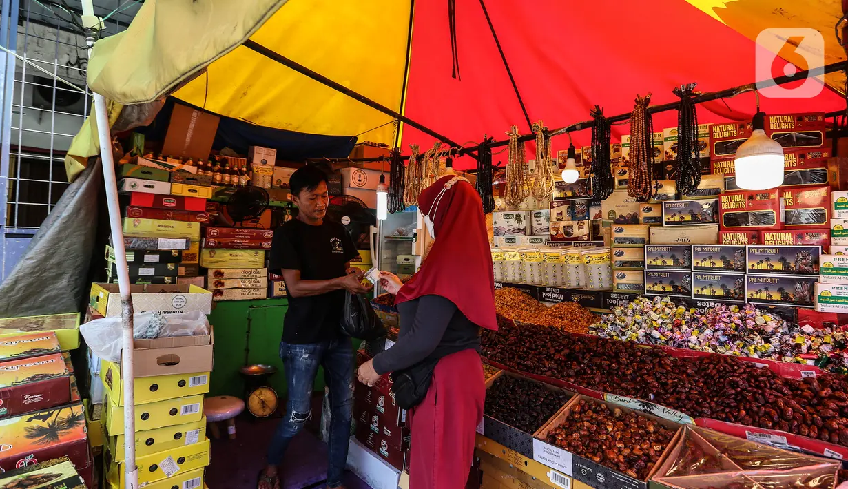 Pedagang kurma melayani pembeli di kawasan Tanah abang, Jakarta, Minggu (3/4/2022). Omset penjualan kebutuhan bulan Ramadhan seperti perlengkapan ibadah dan buah kurma kembali meningkat dibandingkan dua tahun terakhir yang terdampak pandemi COVID-19. (Liputan6.com/Johan Tallo)