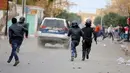 Polisi mengejar pengunjuk rasa yang melakukan aksi protes di luar kantor pemerintah setempat di Kasserine, Tunisia, Kamis (21/1). Para pengangguran muda turun ke jalan memprotes keterpurukan ekonomi dan sulitnya lapangan kerja. (REUTERS/Amine Ben Aziza)