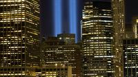 Sorotan cahaya kembar berwarna biru untuk peringati peristiwa serangan 9/11 di Kota New York, Minggu (10/9). Dua cahaya biru tegak lurus itu melambangkan menara kembar WTC yang menjadi sasaran serangan bunuh diri tersebut. (AP Photo/Mark Lennihan)