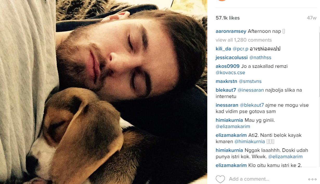 Pemain Arsenal, Aaron Ramsey terlihat pulas dengan anjing kesangannya. (Photo/Instagram) 