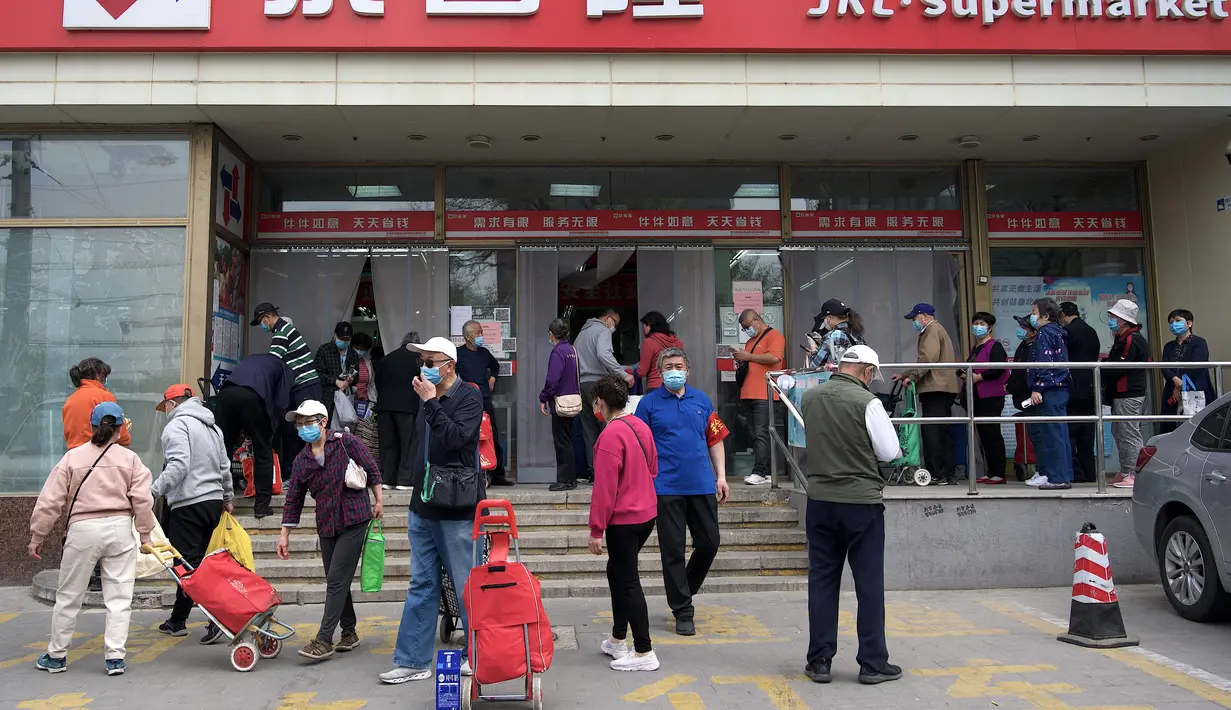 <p>Orang-orang mengantre di luar supermarket untuk membeli persediaan makanan di Beijing pada 25 April 2022. Kekhawatiran penguncian Covid memicu pembelian panik dan antrean panjang untuk pengujian massal di Beijing pada 25 April ketika otoritas China bergegas untuk membasmi wabah di ibu kota. (AFP/Noel Celis)</p>