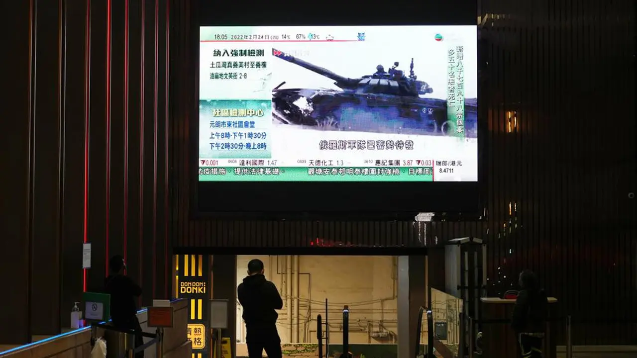 Seorang pria menonton layar TV besar yang menyiarkan berita tentang pasukan Rusia yang telah meluncurkan serangan mereka ke Ukraina, di Hong Kong Kamis, 24 Februari 2022. (AP/Vincent Yu)