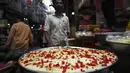 Dalam gambar pada 3 April 2022, penjaga toko yang menjual hidangan manis menunggu pelanggan di pasar pada hari pertama bulan suci Ramadhan di kawasan tua Delhi, India. Masjid dan jalan-jalan pasar penuh dengan keramaian malam, tergoda oleh aroma manisan manis untuk berbuka puasa. (Money SHARMA/AFP)