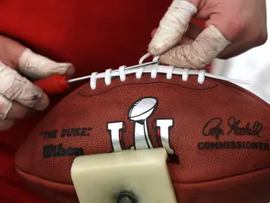 Pekerja mengikat bola American Football yang akan digunakan untuk NFL Super Bowl LI di pabrik di Wilson Sporting Goods di  Ada, Ohio, AS (23/1). (AP Photo/Charles Rex Arbogast)