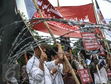 Para massa membawa poster kecaman saat menggelar aksi unjuk rasa di depan Istana Merdeka, Jakarta, Kamis (24/11). Dalam aksinya mereka mengecam keras pembunuhan kaum minoritas muslim di Rohingya, Myanmar. (Liputan6.com/Faizal Fanani)
