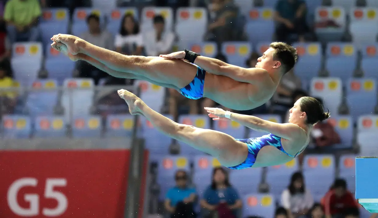 Aksi atlet loncat indah Amerika Serikat, Olivia Rosendahl dan Zachary Cooper saat tampil pada babak final platform sinkronisasi 10 meter campuran di Kejuaraan Renang Dunia, Gwangju, Korea Selatan, Sabtu (13/7/2019). (AP Photo/Lee Jin-man)